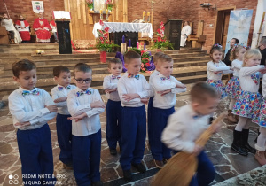 Przedszkolaki tańczą przed ołtarzem w kościele